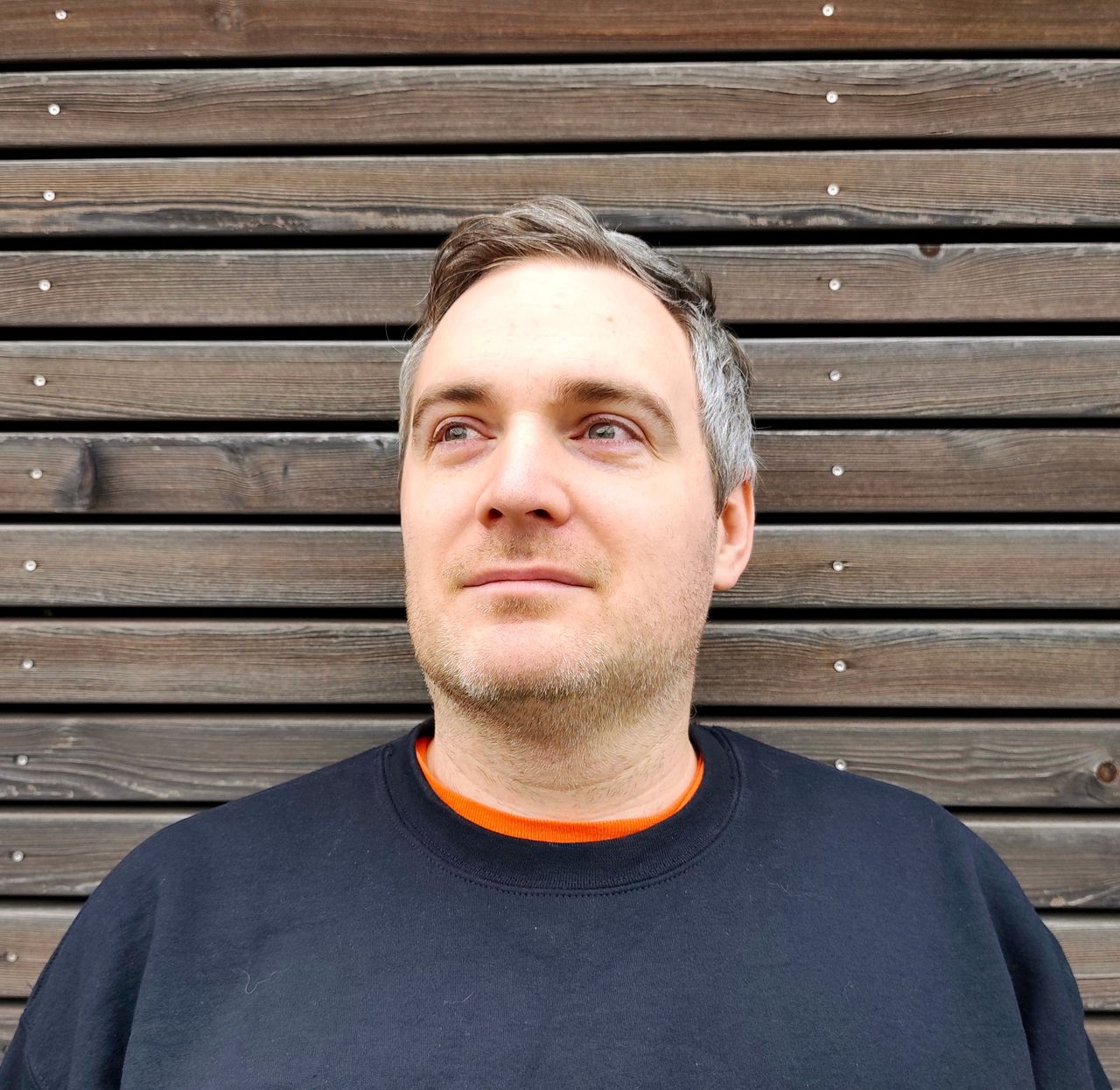 Grid Theory portrait against a weathered wooden wall