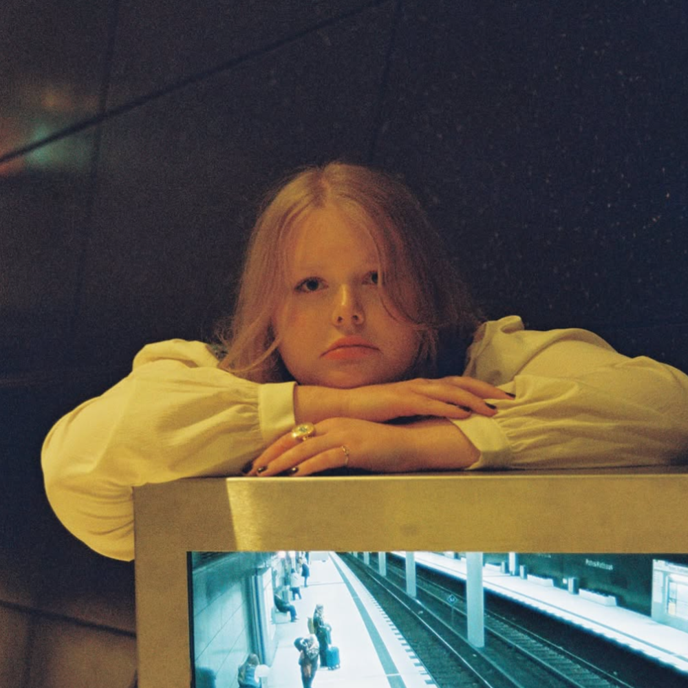 Annalea Dorothee leaning on a ledge above a train platform