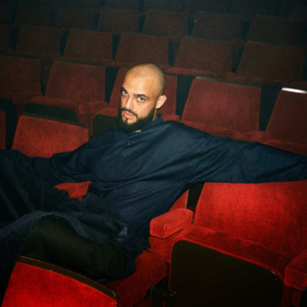 Argyle lounging across red theatre seats