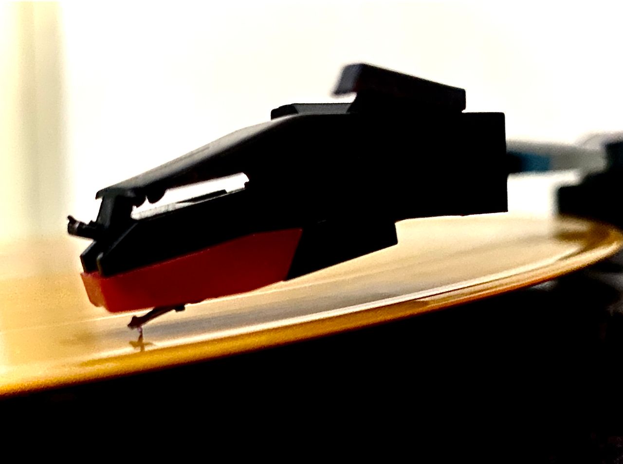 Close-up of a turntable cartridge on a spinning record