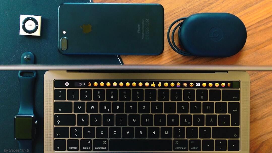 Flat lay of an iPod shuffle, iPhone, earphone case, Apple Watch and MacBook keyboard
