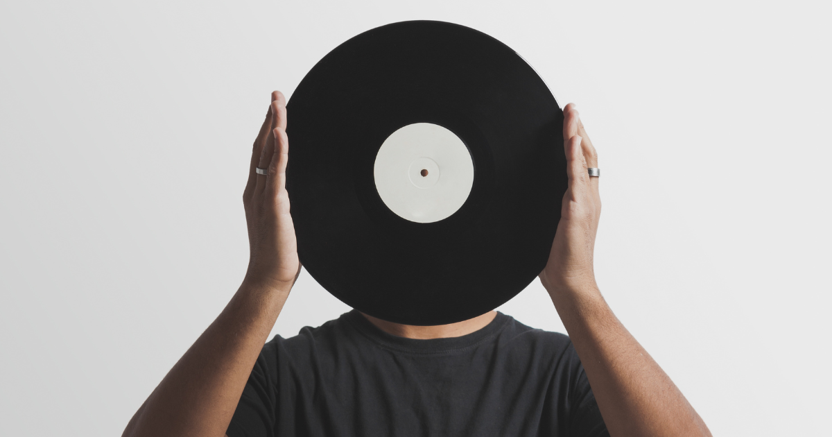Person holding a vinyl record up in front of their face