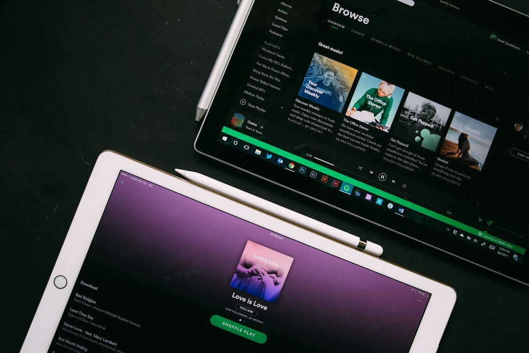 Two tablets showing Spotify's browse and playlist screens