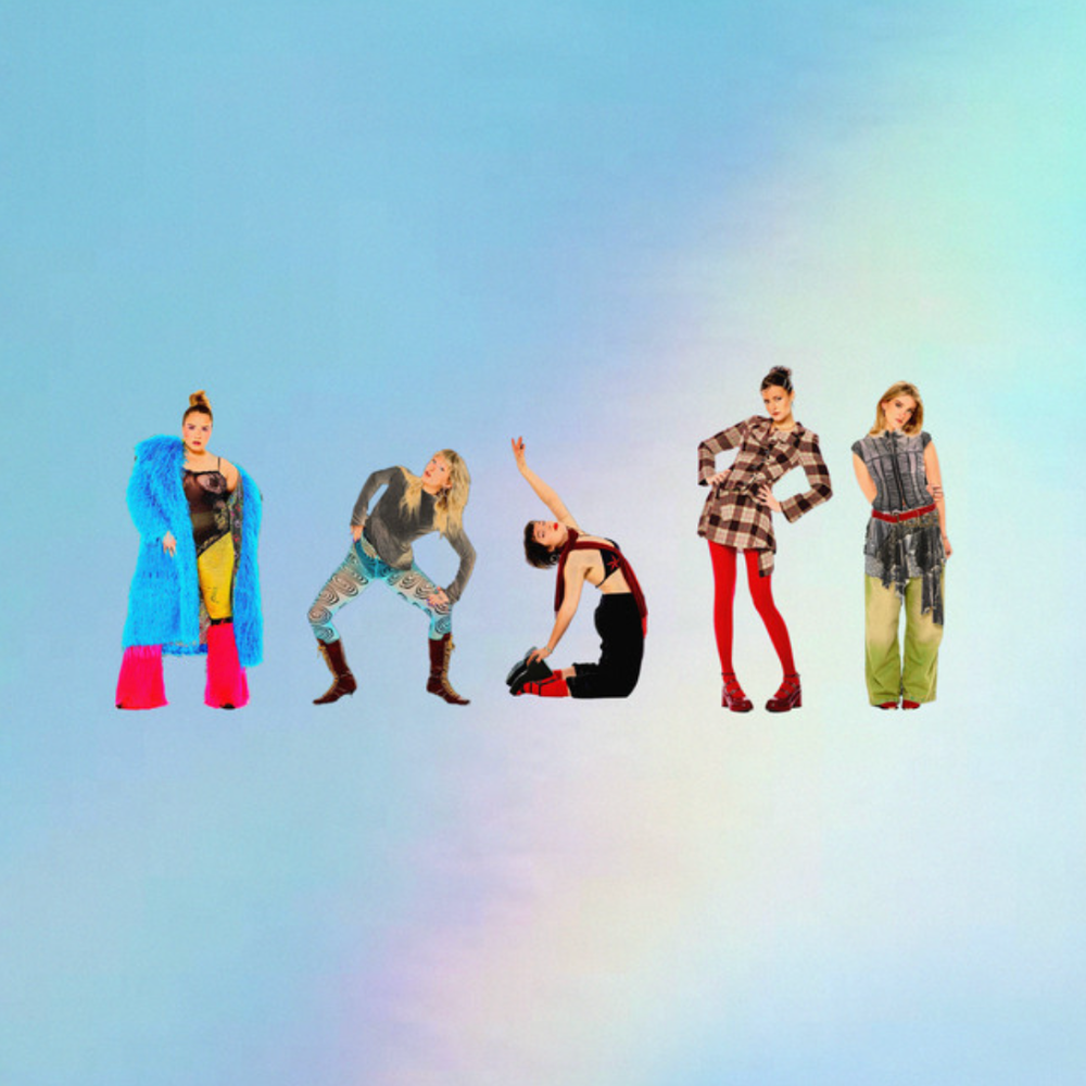 Girl Group, five members in colourful outfits posed against a pale sky