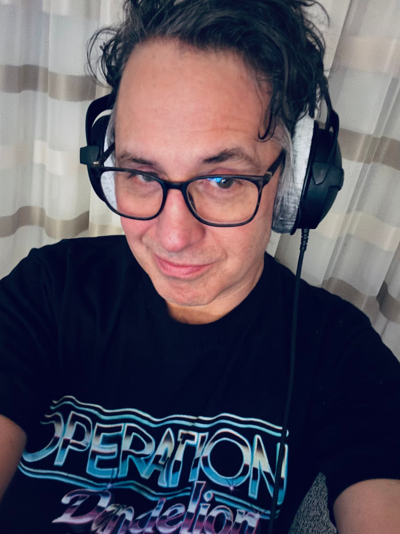The Static Dive in glasses and headphones, smiling at the camera