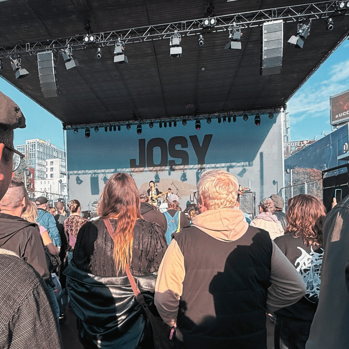 Crowd watching JOSY perform on an outdoor stage with her name on the backdrop
