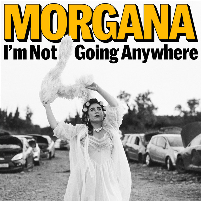 MORGANA - I'm Not Going Anywhere: black and white shot of her in a frilly gown in a car scrapyard