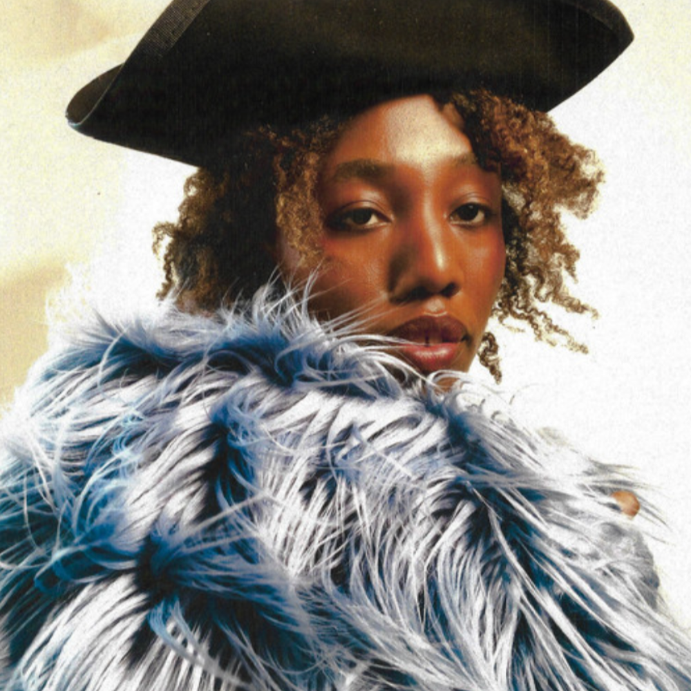 Woman in a black hat and blue-white faux fur coat looking into the camera