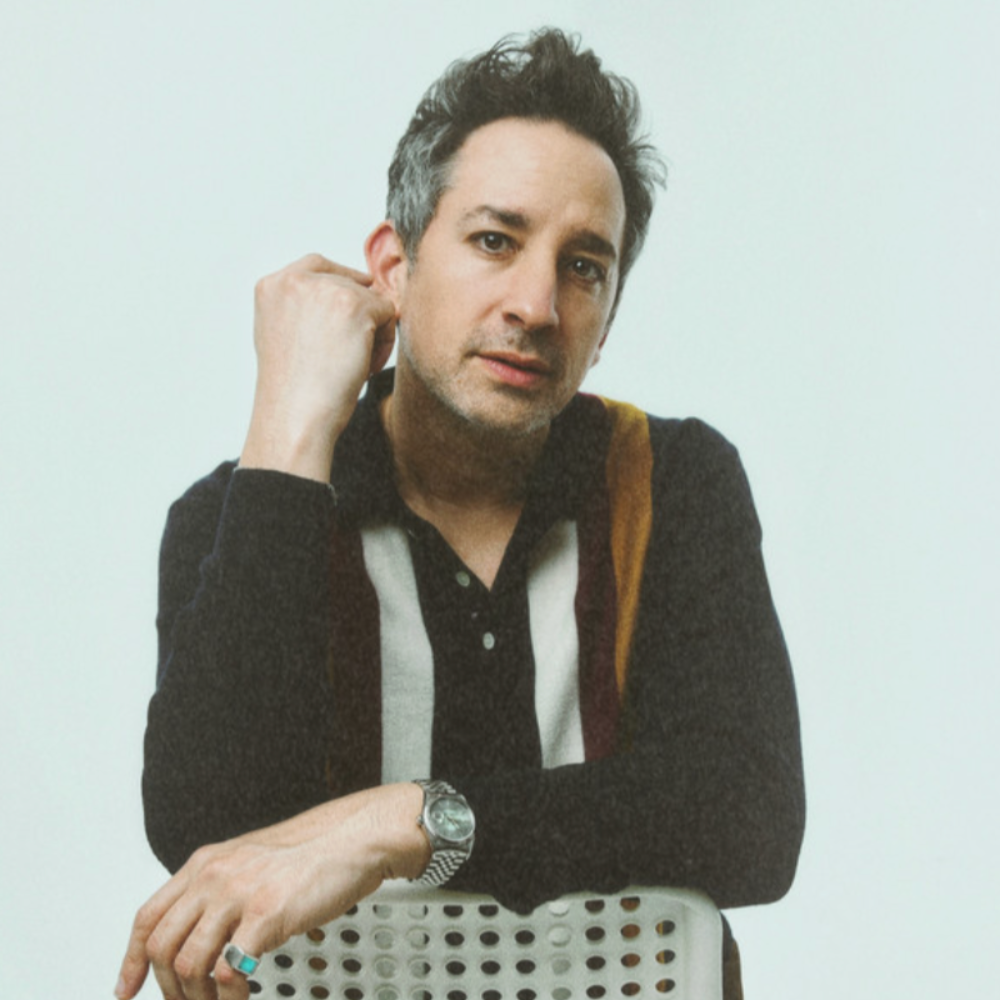 GoldFord leaning on a chair against a pale background