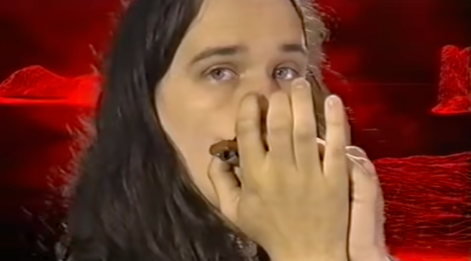 YouTube thumbnail for King Gizzard and the Lizard Wizard's Rattlesnake, a long-haired musician against red