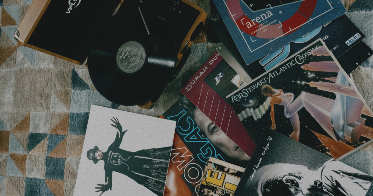 Old vinyl records and sleeves scattered on a patterned rug