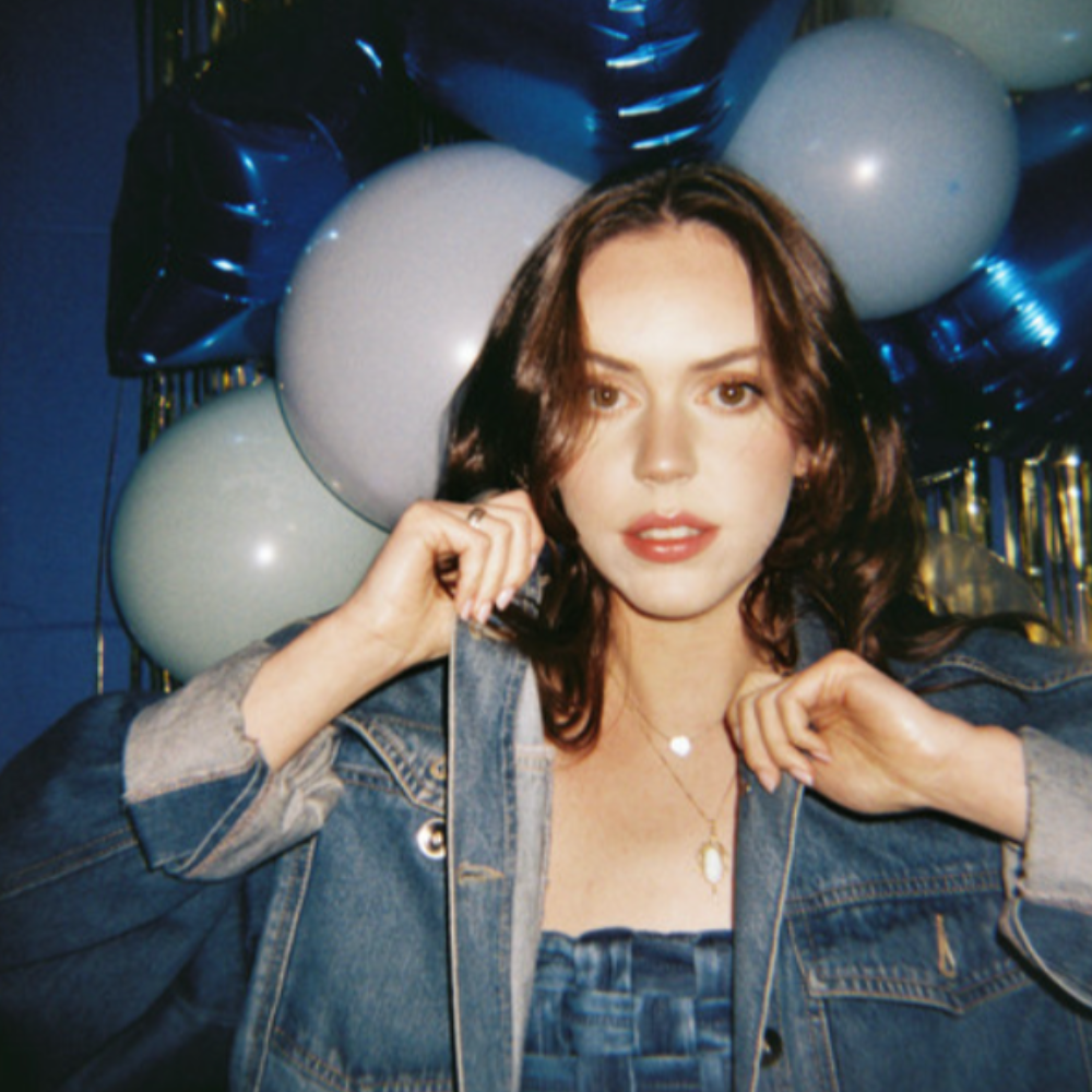 Woman in a denim jacket in front of blue and white balloons