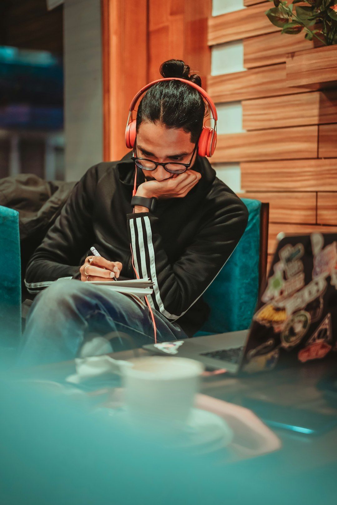 Boy writing ideas in a Diary at Cafe