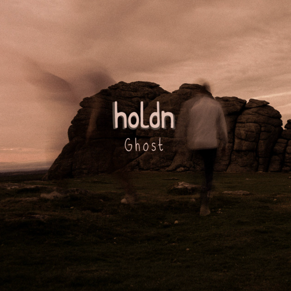 Ghost cover by holdn - a blurred figure walking past a rocky outcrop at dusk