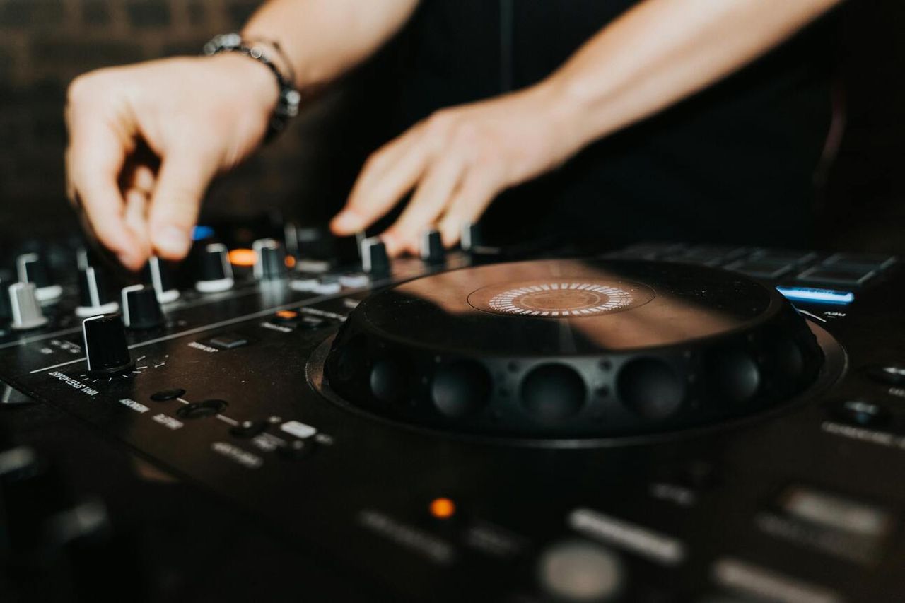 Hands on a DJ controller's jog wheel and knobs