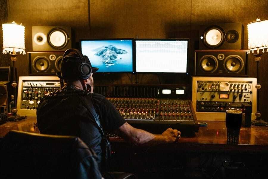 Sound engineer in headphones at a studio mixing desk, for Tidal dropping MQA for FLAC