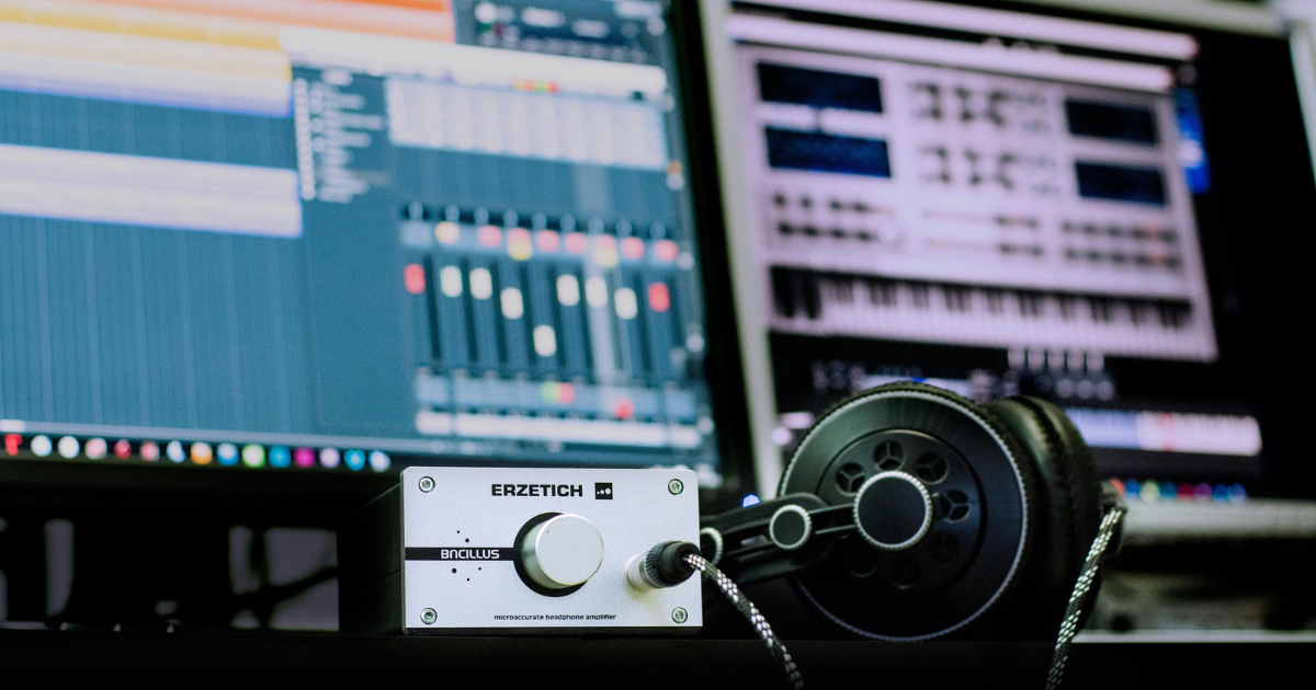 Studio desk with a mixing screen, audio interface and headphones