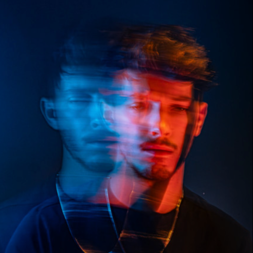 Lucas Geddes in a double-exposure portrait lit red and blue