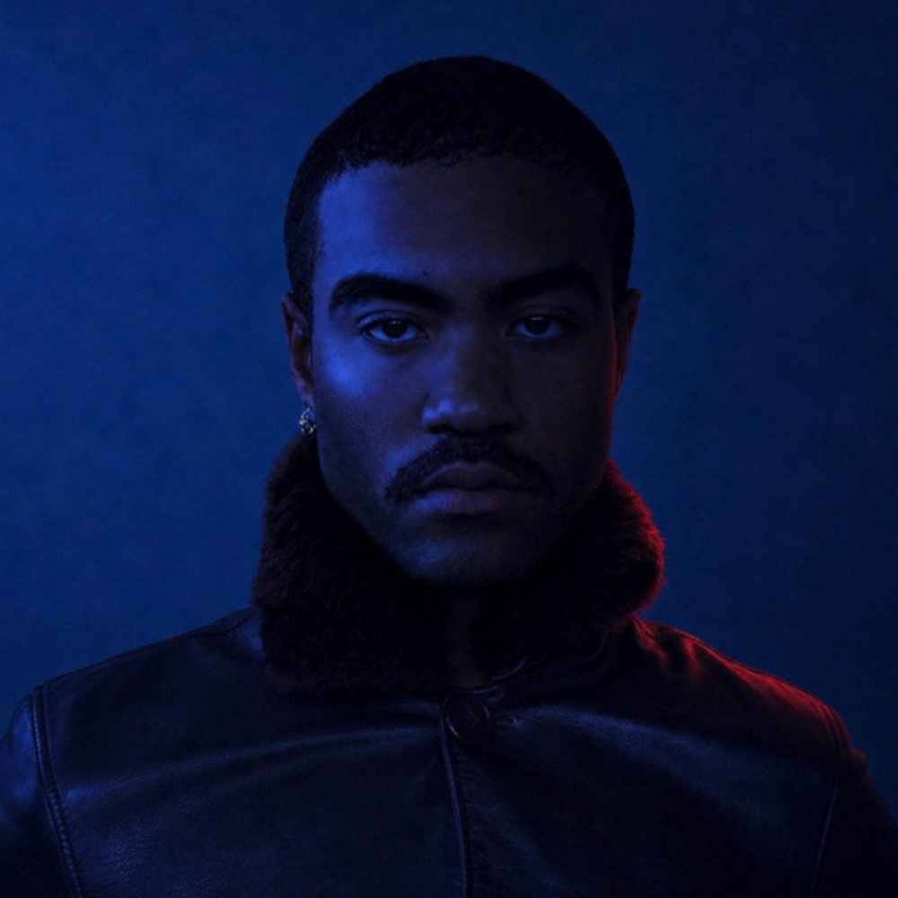 Portrait of a man in a fur-collared jacket under deep blue light