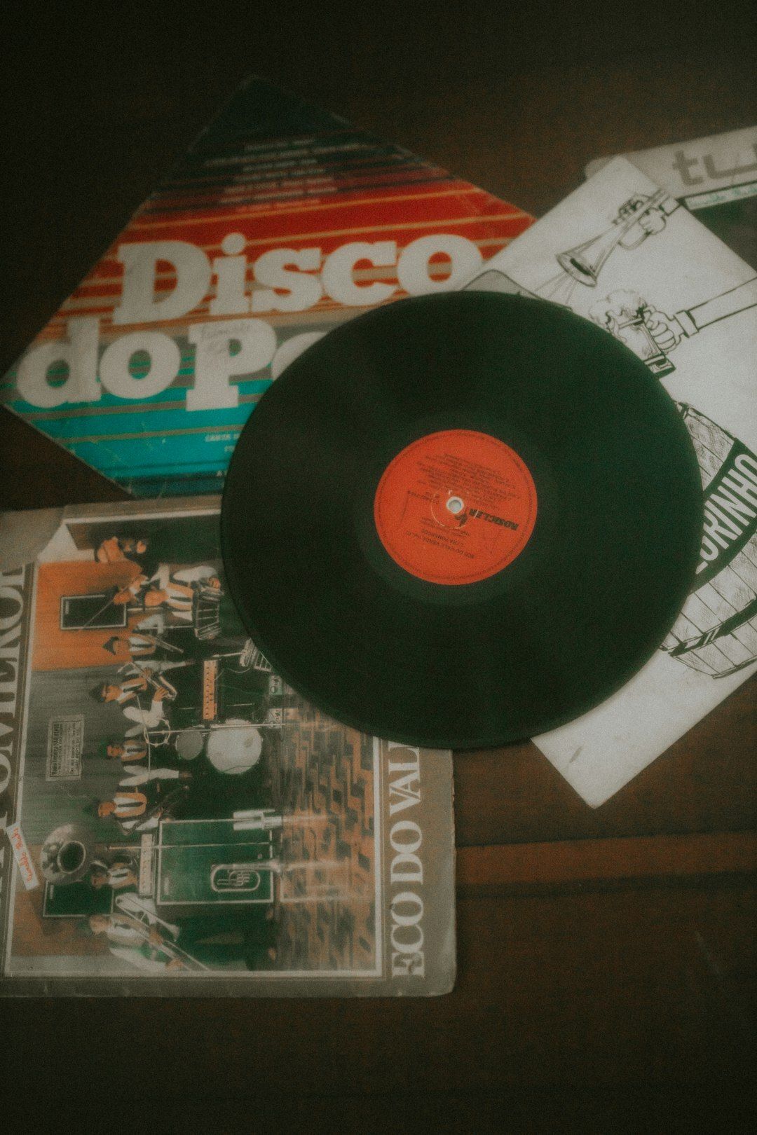 A vinyl record lying on old LP sleeves