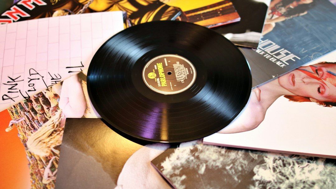 A vinyl record on a pile of LP sleeves including Pink Floyd's The Wall
