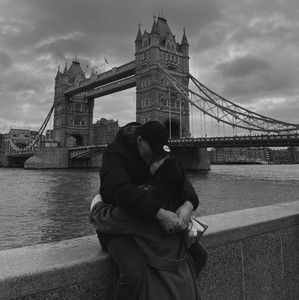 Black and white cover for the indie love mood playlist - a couple embracing by Tower Bridge