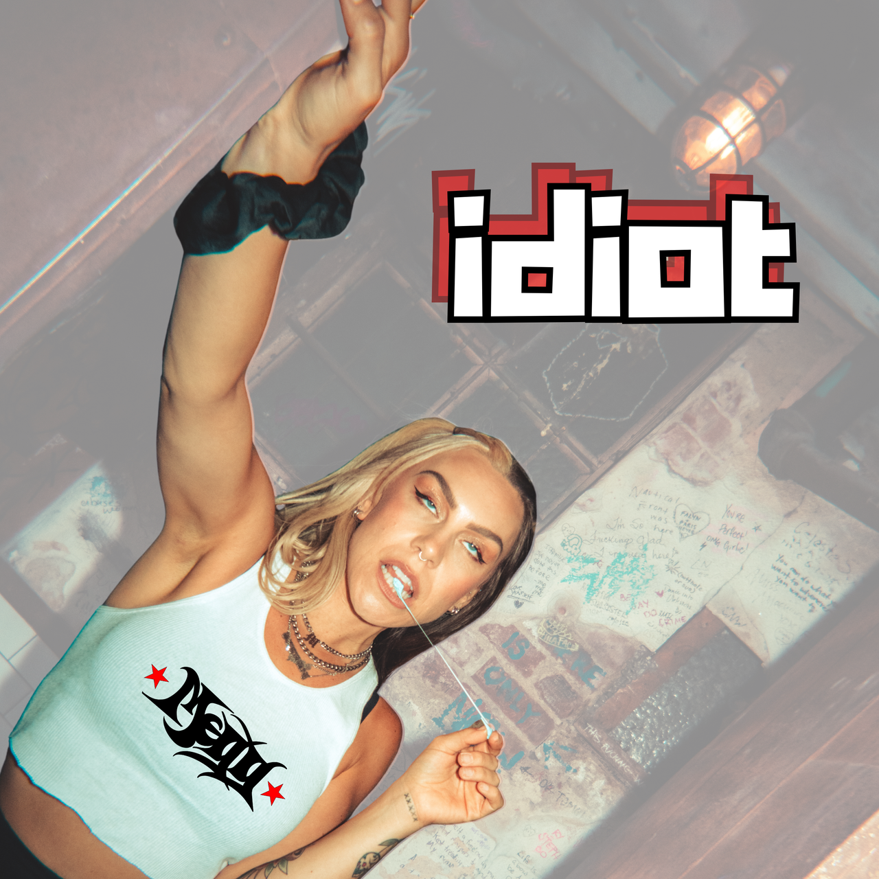 Cover art for IDIOT by MEGG - MEGG reaching up in a white crop top, 'idiot' in pixel letters